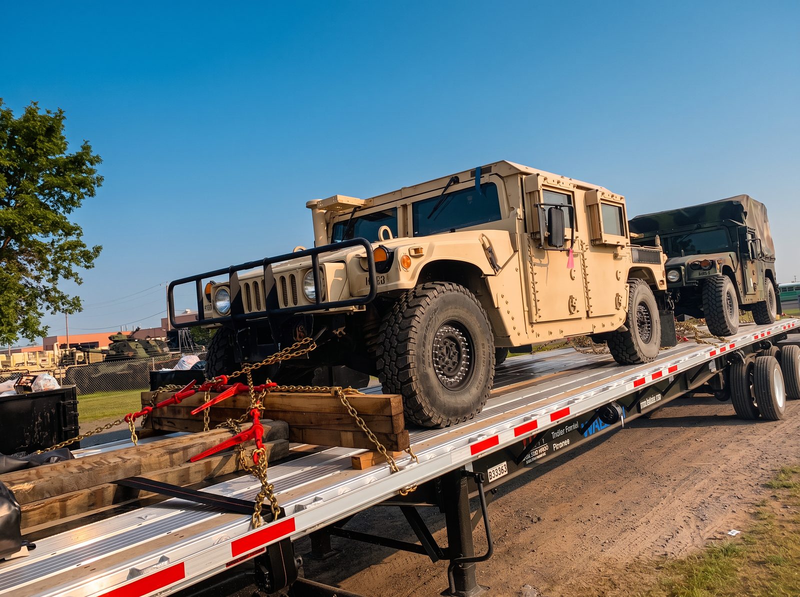 Tactical utility vehicles blocked, braced and chained on an aluminum flatbed trailer